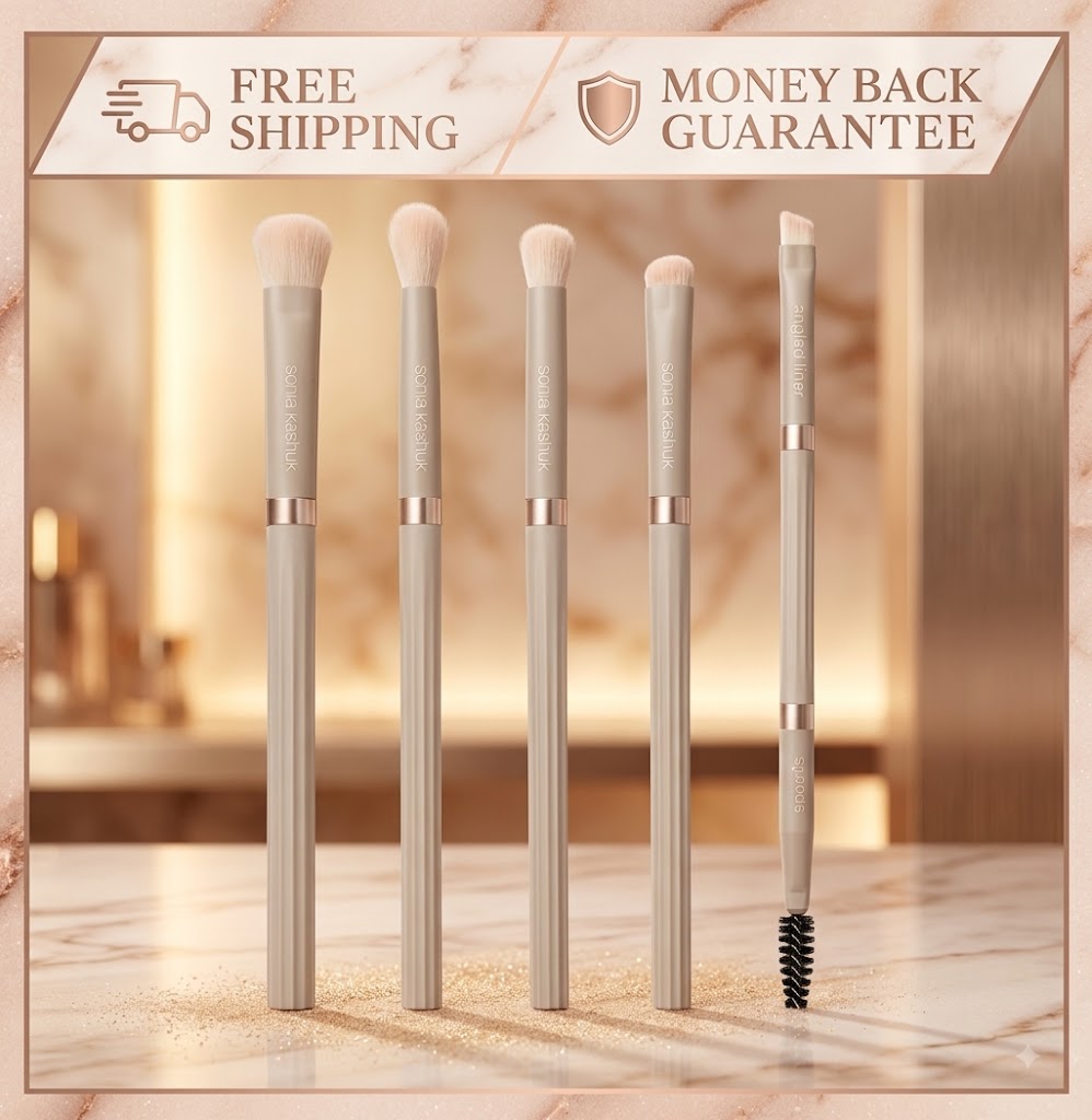 Five makeup brushes with slim metallic handles and soft bristles are displayed on a marble surface. The set includes a brush, eye brush, face brush, brow/lash brush, and spoolie.